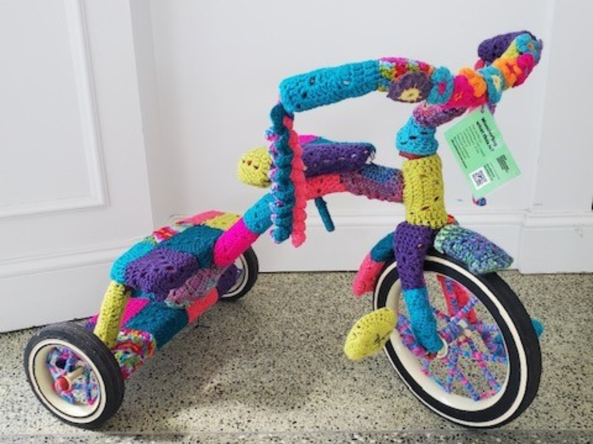 A tricycle that has been covered in yarn 