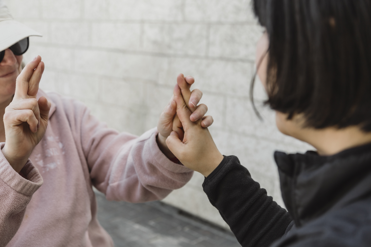 Une intervenante montre comment fonctionne l'ASL tactile avec une cliente. La signeuse communique en ASL, et la personne qui reçoit utilise ses mains pour sentir les signes au fur et à mesure qu'ils sont faits